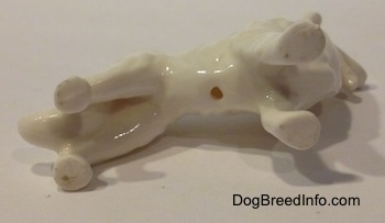 The underside of a bone china white Rough Collie figurine that has a hole in it.