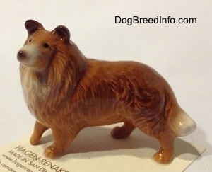 The left side of a brown with white Collie dog figurine that has great hair details.