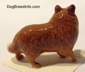The right side of a Collie dog figurine. The figurine has detailed paws.
