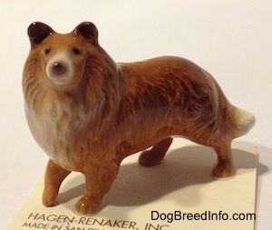 The left side of a figurine that is a Collie dog. The figurine has great face details.