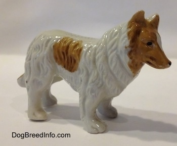 The right side of a white with tan bone chine Rough Collie figurine. The figurine has hair details along its body.