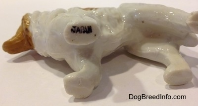 The underside of a bone china Rough Collie figurine that has a JAPAN stamp on its front left paw.