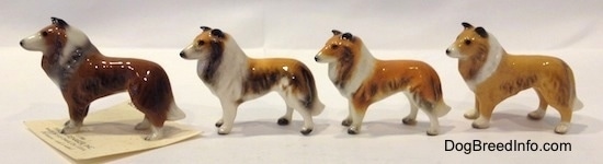 The left side of four different variations of a Collie dog figurine. All of the figurines have black circles for eyes.