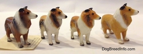 The front right side of figurines that are variations of a Collie dog. All of the figurines hace black nails on the paws.