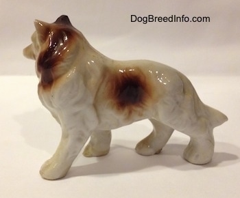 The left side of a porcelain figurine that is a brown and white Rough Collie. The figurine has fine fur details.