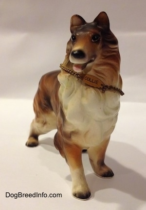 A ceramic brown, black and white Rough Collie figurine that is wearing a chain ID that reads - COLLIE - on it.