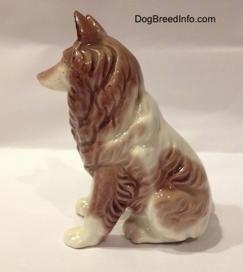 The left side of a brown and white porcelain Rough Collie figurine that has its ears up.