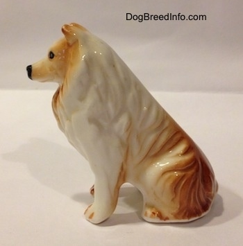 The right side of a tan and white bone china Rough Collie figurine. The figurine has tan on top of its paws.