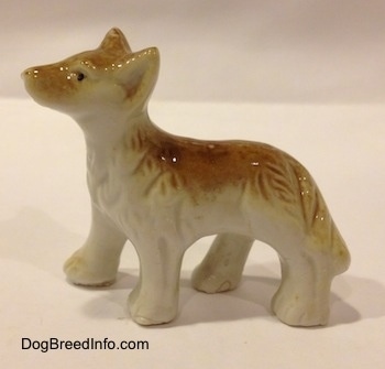 The left side of a bone china tan and white Coyote figurine. The figurine has few details in its face.