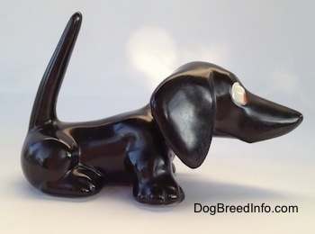 The right side of a black Dachshund figurine. The figurine has a long nose.