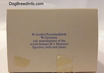The underside of a box with the words - W. Goebel Porzellanfabrik W.-Germany solo manufacturer of world-famous M.I. Hummel Figurines, bells and plates on it. There is tape on it and there is a tape residue under the words.