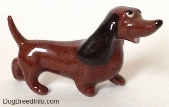 The right side of a brown Dachshund figurine named 'Dachsie' that is from 'Disney's The Lady and the Tramp'. The figurines ears are long and black.