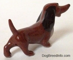 The back right side of a brown figurine that has a long nose, long body and short legs.