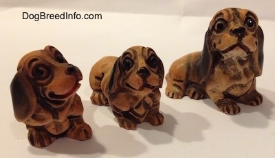 The front right side of three different plastic Dachshund figurines. The figurine have smiles on there faces.