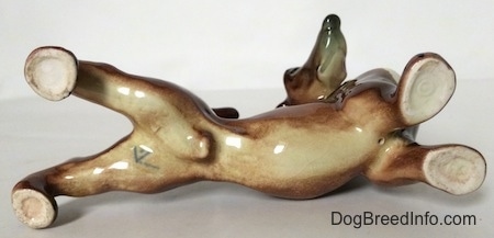 The underside of a brown with white Dachshund figurine. There is a Goebel W.Germany stamp on the bottom of the figurine.