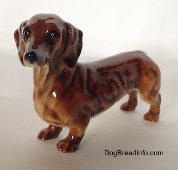 A brown Dachshund figurine. The figurine has fine face details.