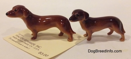 The left side of two Dachshund Mama standing figurines. The figurines have small black eyes.