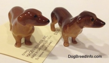 Two Dachshund Mama standing figurines have ears that are hard to differentiate from there bodies.