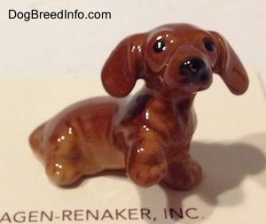 The right side of a Dachshund Puppy Seated Paw Up figurine. The ears of the figurines are sticking out.