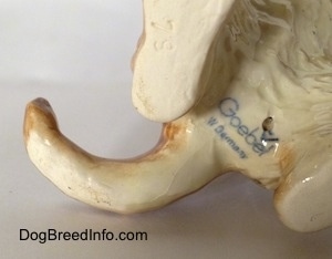 Close up - The underside of a Dachshund figurine in a begging pose. There is a Goebel W.Germany logo on the bottom of the figurine.