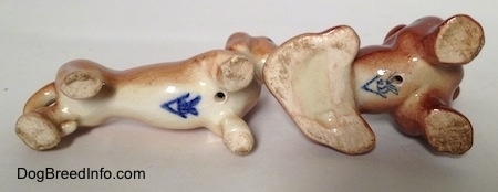 The underside of two different Dachshund figurines. On the bottom of both figurines are the Goebel W.Germany logo.