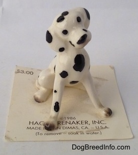 A hand painted Dalmatian figurine in a sitting position. The Dalmatian has black circles for eyes.