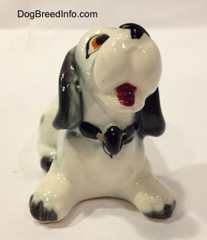 A Dalmatian puppy figurine that looks cartoon-y. The figurine has black tipped paws.