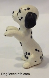 The left side of a Dalmatian puppy figurine that is in a begging pose. The figurine has black ears and short appendages.