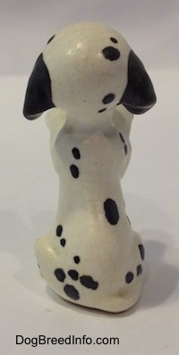 The back of a Dalmatian puppy figurine that is in a begging pose. The figurines tail is hard to differentiate from its body.