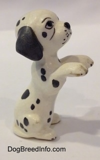 The right side of a figurine that is a Dalmatian puppy in a begging pose. It is hard to differentiate the tail of the figurine from its body.