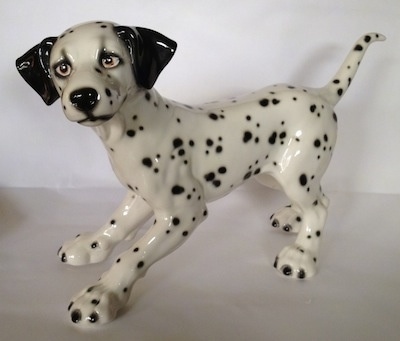 The left side of a Dalmatian figurine. The figurine has a long legs and big paws.
