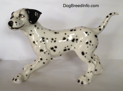 The left side of a Dalmatian figurine. The figurine has a smile painted on its face.