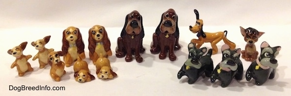 A line-up of fifteen dog figurines that are of famous Disney dog characters.