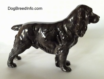 The right side of a figurine that is of a blue roan English Cocker Spaniel. It is hard to tell the difference between the ears and the head of the figurine.