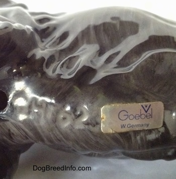 Close up - The underside of a English Cocker Spaniel figurine. There is a stick on the underside and it has the text logo of Goebel W.Germany on it.