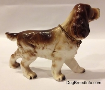 The right side of a brown and white English Cocker Spaniel porcelain figurine. The figurine has fine hair details.