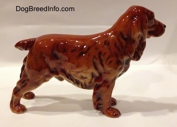 The right side of a red English Cocker Spaniel figurine. The figurine has a short tail.