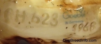 Close up - The underside of a English Cocker Spaniel figurine. On the underside there is the text logo stamp of Goebel W.Germany. There are also numbers and letters engraved on the underside - CH623 - and - 1968.