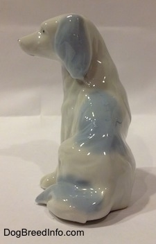 The back of a white with blue bone china English Setter figurine. There is a large blue spot on the back of the figurine.