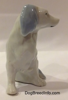 A white with blue bone china English Setter figurine. The ears of the figurine are blue.