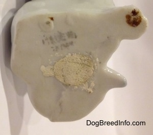 The underside of a bone china English Setter that has a filled in hole.