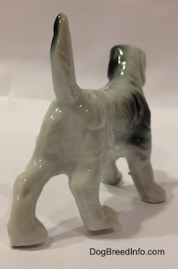 The back of a black and white bone china English Setter figurine. The tail of the figurine is sticking straight up in the air.