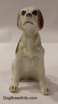 A white with brown bone china English Setter figurine, the figurine has brown nails on its small paws.