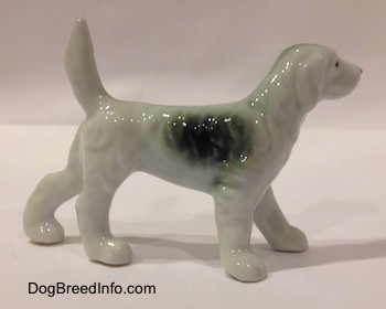 The right side of a white with black bone china English Setter figurine. The ears of the figurine are hard to differentiate from its body.