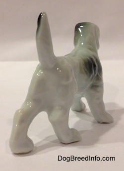 The back right side of a white with black bone china English Setter figurine. The figurine is glossy.