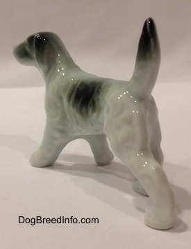 The back left side of a bone china figurine of a white with black English Setter. The figurine has black tips around its tail.