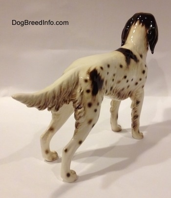 The back right side of a brown and white English Setter porcelain figurine. The figurine has a detailed body.
