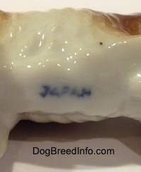 Close up - The underside of a bone china English Setter figurine and on the underside is a stamp that reads - JAPAN.