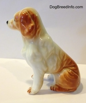 The left side of a red and white bone china English Setter figurine. Its hard to tell the difference between the ears of the figurine from its head.