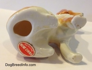 The underside of a bone china English Setter figurine. There is a hole in the figurine and under that is a sticker that reads - Genuine Bone China.